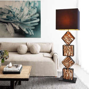 Eine Holz Stehlampe mit einem großen Schwarzen Lampenschirm steht im Wohnzimmer