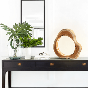 Im Wohnzimmer auf einer Konsole steht eine Tischlampe aus Holz mit LED Beleuchtung